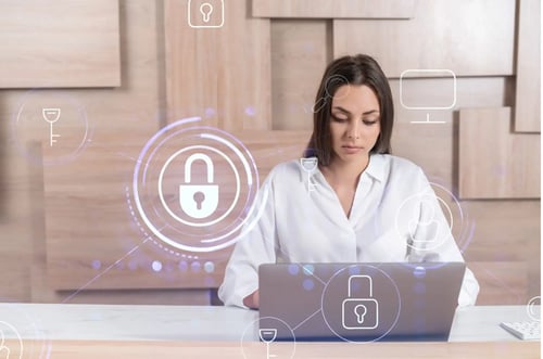 A young woman sitting at a laptop securing data in accordance with the best practices for information governance.